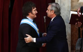 Argentina's incoming president Javier Milei (L) shakes hands with outgoing President Alberto Fernandez after receiving the presidential sash during his inauguration ceremony at the Congress in Buenos Aires on December 10, 2023. Libertarian economist Javier Milei was sworn in Sunday as Argentina's president, after a resounding election victory fueled by fury over the country's economic crisis. "I swear to God and country... to carry out with loyalty and patriotism the position of President of the Argentine Nation," he said as he took the oath of office, before outgoing President Alberto Fernandez placed the presidental sash over his shoulders. (Photo by ALEJANDRO PAGNI / AFP)