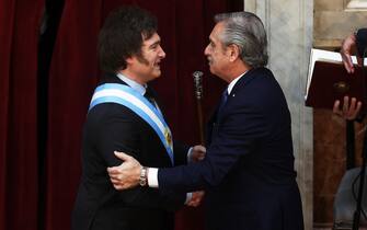 Argentina's incoming president Javier Milei (L) shakes hands with outgoing President Alberto Fernandez after receiving the presidential sash during his inauguration ceremony at the Congress in Buenos Aires on December 10, 2023. Libertarian economist Javier Milei was sworn in Sunday as Argentina's president, after a resounding election victory fueled by fury over the country's economic crisis. 