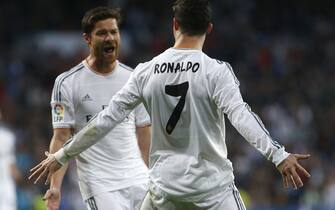 epa04117649 Real Madrid's Portuguese striker Cristiano Ronaldo (R) celebrates with his team mate Xabi Alonso after scoring the opening goal during the Spanish Liga's Primera Division match between Real Madrid and Levante at Santiago Bernabeu stadium in Madrid, central Spain, 09 March 2014.  EPA/JUANJO MARTIN