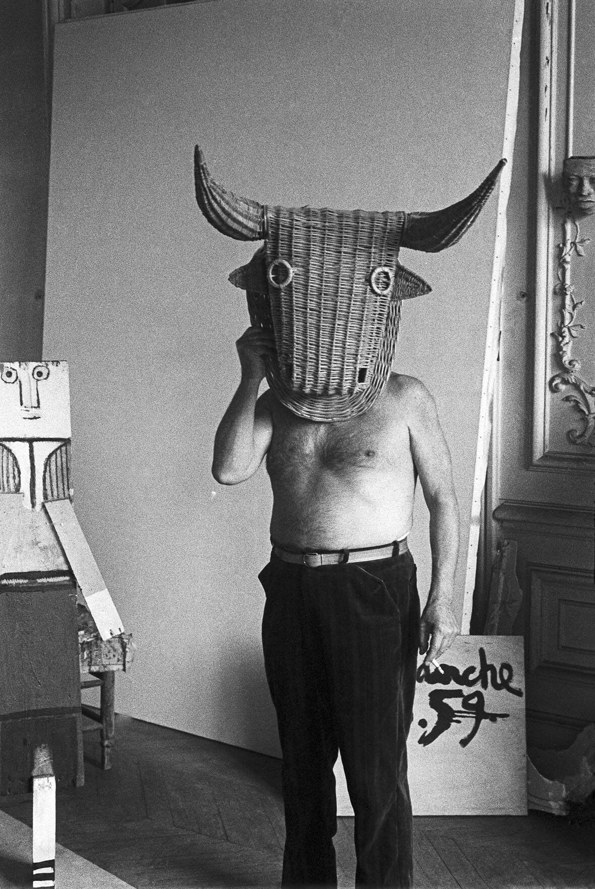 Edward-Quinn-Picasso-with-a-wicker-mask..jpg