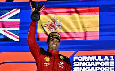 Ferrari's Spanish driver Carlos Sainz Jr celebrates on the podium after winning the Singapore Formula One Grand Prix night race at the Marina Bay Street Circuit in Singapore on September 17, 2023. (Photo by Lillian SUWANRUMPHA / AFP) (Photo by LILLIAN SUWANRUMPHA/AFP via Getty Images)