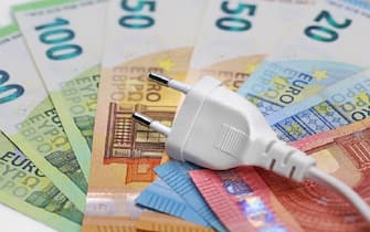 white plug on euro banknotes, concept of electricity price increase.