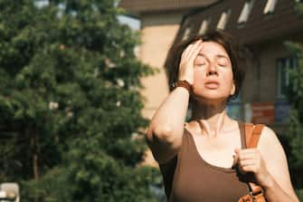 Mature woman is feeling bad during the heat wave in city