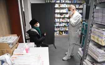 Un farmacista ascolta una signora prima di somministrare la terza dose di Pfizer in una farmacia di Milano, 10 novembre 2021. ANSA/DANIEL DAL ZENNARO
