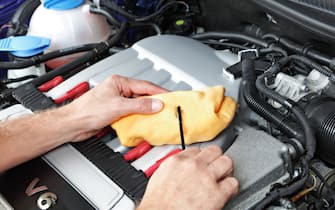 Mechanic checking motor oil
