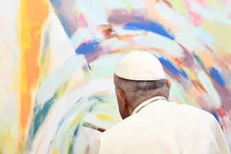Pope Francis paints a mural during a meeting with young members of Scholas Occurentes educational foundation in Cascais, during his five-day visit to attend the World Youth Day (WYD) gathering of young Catholics, on August 3, 2023. - Portugal is expecting about a million pilgrims from around the world, according to organisers, to attend the World Youth Day gathering of young Catholics from August 1 to 6. Originally scheduled for August 2022, the event was postponed because of the Covid-19 pandemic.ANSA/Marco BERTORELLO / AFP