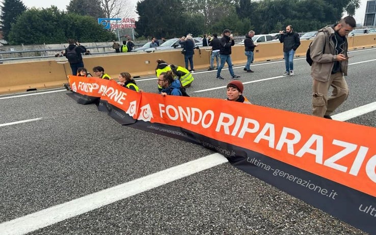 Il blitz degli ambientalisti di Ultima Generazione, circa una ventina, che hanno bloccato in entrambe le direzioni l'autostrada A4 Torino-Milano, nelle vicinanza dell'imbocco di corso Giulio Cesare. Gli attivisti si sono seduti per terra e hanno aperto uno striscione con scritto 'Fondo riparazione', 19 ottobre 2023. ANSA/DOI