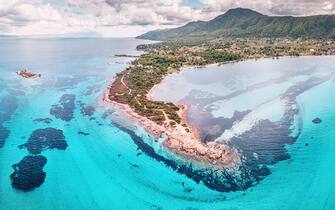 Amazing aerial view of the paradise seacoast with various shades of turquoise water. Idyllic sandy beaches and blue lagoons and bays in the resort village of Vourvourou in Halkidiki, Greece