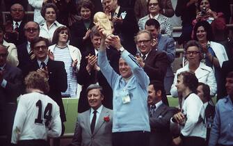 (GERMANY OUT) 1974 FIFA World Cup in Germany Final in Munich: Germany 2 - 1 Netherlands - Coach Helmut Schoen holding up the trophy at the award ceremony| from left: Uli Hoeness, German Chancellor Helmut Schmidt - 07.07.1974 Identical with image no 396477 ! (Photo by Werner Schulze/ullstein bild via Getty Images)