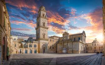 Panorama of Lecce, Puglia, Italy at sunset. Piazza del Duomo square, Campanile tower and Virgin Mary Cathedral (Basilica di Santa Maria Assunta in Cielo), Caritas Diocesana. Baroque city of Apulia