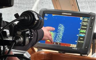 26 August 2023, Great Britain, Drumnadrochit: Skipper Ali Matheson points to a sonar image of Loch Ness. In Scotland, what is believed to be the largest search for the Loch Ness monster, known as Nessie, in decades began on Saturday. Dozens of volunteers from around the world posted themselves on Saturday morning in partly pouring rain at 17 observation posts around the famous lake in the Highlands. During the day, boats with special technology such as a hydrophone - a kind of underwater microphone - were to cruise Loch Ness. The use of drones with thermal imaging cameras was also planned. (to dpa ""Largest Nessie search in decades" begins in Scotland") Photo: Benedikt von Imhoff/dpa (Photo by Benedikt von Imhoff/picture alliance via Getty Images)