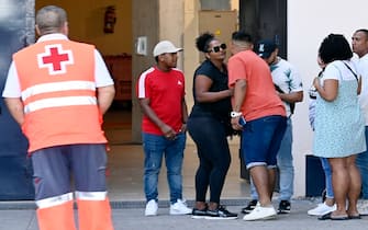 Relatives of the victims killed in a fire at a nightclub in Murcia, gather outside the city's Sports Pavillion where they have received psychological assistance on October 1, 2023. At least 13 people were killed in a fire in a Spanish nightclub today morning, authorities said, with fears the toll could still rise as rescue workers sift through the debris. The fire appears to have broken out in a building housing the "Teatre" and "Fonda Milagros" clubs in the city of Murcia in southeastern Spain in the early morning hours. (Photo by JOSE JORDAN / AFP) (Photo by JOSE JORDAN/AFP via Getty Images)