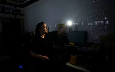 epaselect epa12061257 A woman uses her mobile phone torch inside a store during a power outage, in Madrid, Spain, 28 April 2025. A power blackout hit large parts of Spain and spread to neighbouring Portugal and France, disrupting transport systems, internet connections and daily life, according to authorities. The exact cause of the outage is unknown.  EPA/BORJA SANCHEZ-TRILLO