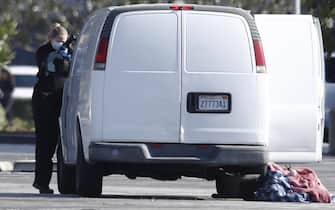 epa10423966 Investigators go through a white van which police reported was connected with a mass shooting at a dance studio in Monterey Park, California, after police entered the vehicle and found dead body in Torrance, California, USA, 22 January 2023. The shooting killed ten and wounded ten more during a Lunar New Year celebration according to the Los Angeles County Sheriff's Department.  EPA/CAROLINE BREHMAN