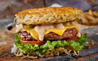 The Fried Ramen Bun Cheeseburger with Lettuce, Tomato, Onions, Pickles, Spicy Mayo and Fries