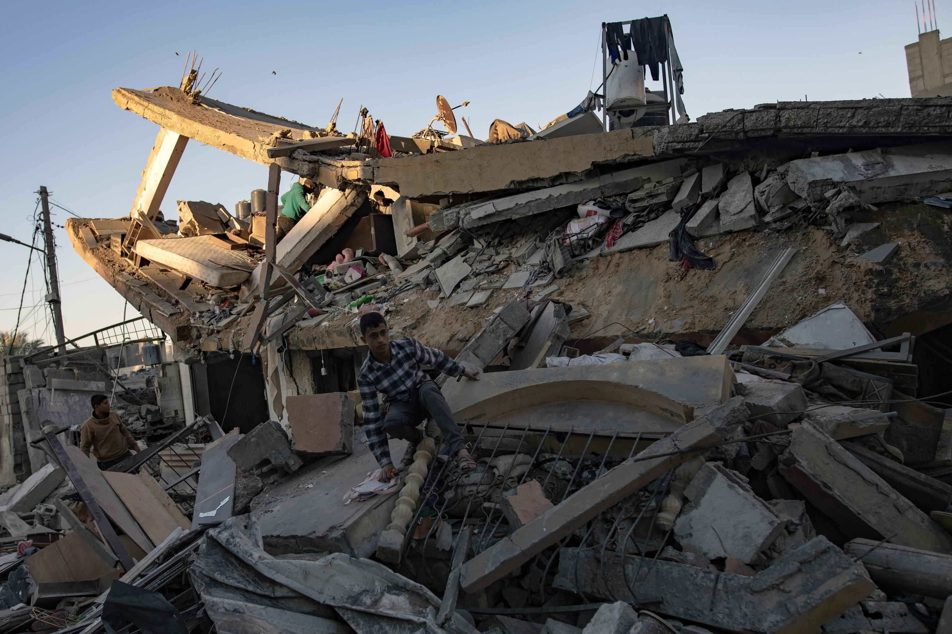 epa11061985 Palestinians from the Brais family search for missing people under the rubble following an Israeli air strike in Khan Yunis, southern Gaza Strip, 07 January 2024. More than 22,300 Palestinians and at least 1,300 Israelis have been killed, according to the Palestinian Health Ministry and the Israel Defense Forces (IDF), since Hamas militants launched an attack against Israel from the Gaza Strip on 07 October, and the Israeli operations in Gaza and the West Bank which followed it.  EPA/HAITHAM IMAD