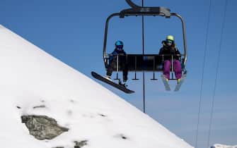 Skiers wearing face masks ride a chairlift on the opening day of the Verbier ski area in the Swiss Alps during the coronavirus disease (COVID-19) outbreak, in Verbier, Switzerland, 30 October 2020.  ANSA/JEAN-CHRISTOPHE BOTT