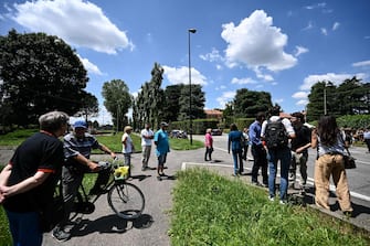 Members of the public gather outside Villa San Martino (rear, C), the residence of Italian businessman and former prime minister Silvio Berlusconi, following his death, in Arcore, northern Italy, on June 12, 2023. Italy's former prime minister Silvio Berlusconi has died aged 86, his spokesman confirmed to AFP on June 12, 2023. The billionaire media mogul was admitted to a Milan hospital on June 9 for what aides said were pre-planned tests related to his leukemia. (Photo by Piero CRUCIATTI / AFP)