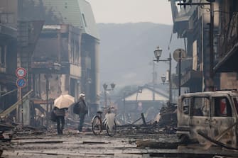 epa11054392 A man stands at the morning market area burnt out by fires which broke out after a  strong earthquake in Wajima, Ishikawa Prefecture, central Japan, 03 January 2024. The Ishikawa Prefecture Government has announced 62 people were killed by the magnitude 7 earthquake (the USGS listed the magnitude as 7.5) which occured on 01 January. About 33,000 residents in Ishikawa Prefecture have evacuated to 355 makeshift evacuation centers. According to Hokuriku Electric Power Company, about 33,900 homes lost electricity in the prefecture.  EPA/JIJI PRESS JAPAN OUT EDITORIAL USE ONLY/
