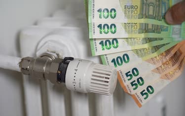 Europa, Italia , L'aumento del costo della bolletta del gas e dell'elettricità provoca un aumento del prezzo per l'approvvigionamento delle materie prime, denaro banconota da 100, 50 euro e radiatore per riscaldamento domestico