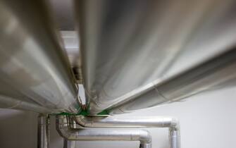 Several metal water or oil pipes parallel fixed to the ceiling horizontal