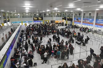 epa07243272 Passengers wait at the departure areas of  Gatwick airport, after it reopens, in Sussex, southeast, England, 21 December 2018. Britain's second busiest airport Gatwick was shut down by authorities after sightings of drones flying but has since then reopened.  EPA/FACUNDO ARRIZABALAGA
