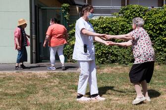 A caregiver holds a resident after meeting her daughter in a bubble at Fondation Shadet Vercoustre nursing home on May 27, 2020 in Bourbourg near Gravelines, France, where a double entry bubble has been installed to allow visits without risk of contamination, as part of a prophylactic measure against the spread of the Covid-19 disease caused by the novel coronavirus. Relatives and residents each enter the tent through a different entrance to find themselves in the same room, separated by a transparent plastic canvas. These bubbles were originally designed for tourism by the company. Photo by Julie Sebadelha/ABACAPRESS.COM