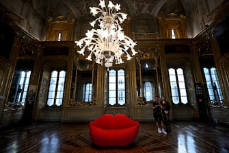 Visitors look at the couch "La Bocca" (The Mouth) presented by Gufram, at the Palazzo Litta as part of the Fuorisalone 2024 event, on the eve of the Milan Design Week, in Milan, on April 15, 2024. (Photo by GABRIEL BOUYS / AFP) / RESTRICTED TO EDITORIAL USE - MANDATORY MENTION OF THE ARTIST UPON PUBLICATION - TO ILLUSTRATE THE EVENT AS SPECIFIED IN THE CAPTION (Photo by GABRIEL BOUYS/AFP via Getty Images)
