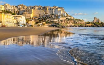 Sperlonga, Italy -- A sunset view of the city of Sperlonga, in the south of Rome, perched on a rocky outcrop facing the Tyrrhenian Sea. Sperlonga was founded by the Romans and became the site of numerous imperial villas, including the famous villa of Emperor Tiberius, whose archaeological remains are still preserved today. Sperlonga is a very popular place in summer for its beautiful and peaceful beaches.