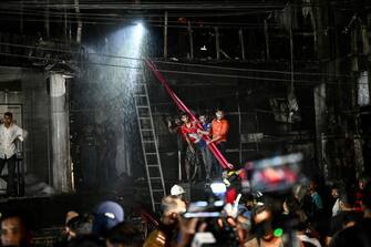 Members of the publichelp as firefighters work to extinguish a fire in a commercial building that killed at least 43 people, in Dhaka, on February 29, 2024. At least 43 people were killed and dozens injured after a fire blazed through a seven-storey building in an upscale neighbourhood in the Bangladeshi capital of Dhaka late on February 29, health authorities said. (Photo by Munir Uz Zaman / AFP) (Photo by MUNIR UZ ZAMAN/AFP via Getty Images)