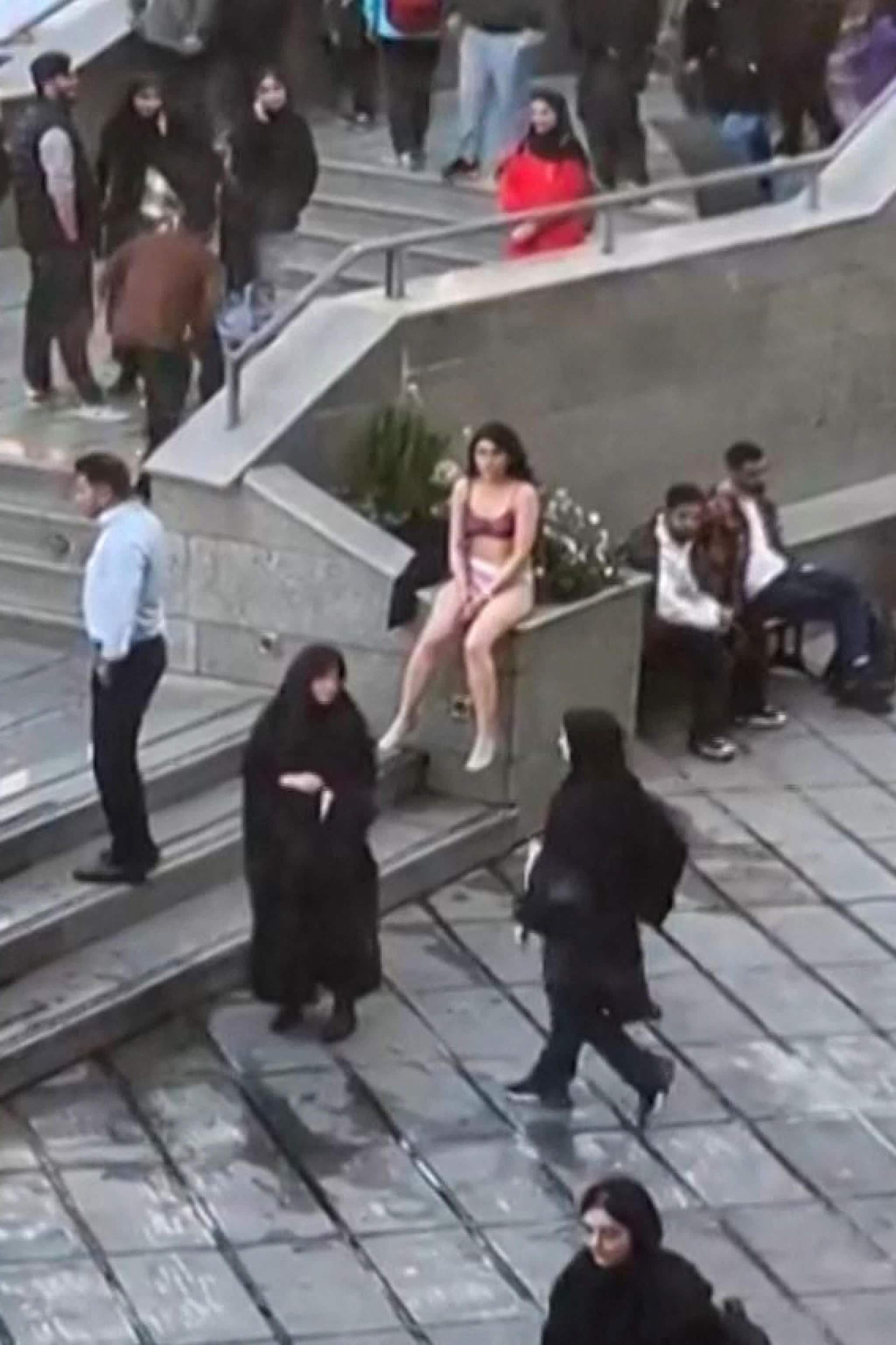 This image grab from a UGC video posted on November 2, 2024, and widely shared on social media shows a female student in her underwear outside Tehran's Islamic Azad University. Iranian authorities arrested the female student on November 2, after she staged a solo protest against harassment according to reports by several news outlets and social media channels outside Iran, an incident confirmed by Iran's conservative Fars news agency, saying she had worn "inappropriate clothes" in class and "stripped" after being warned by security guards to comply with the dress code. (Photo by UGC / AFP) / THIS SOCIAL MEDIA VIDEO WAS FILMED IN TEHRAN, IRAN, AND POSTED ONLINE ON NOVEMBER 2, 2024. IT WAS SOURCED AND AUTHENTICATED BY AFP TEAMS IN NICOSIA AND PARIS. IT IS DISTRIBUTED AS A SERVICE TO CLIENTS 
Israel OUT - XGTY / XGTY/RESTRICTED TO EDITORIAL USE - MANDATORY CREDIT AFP -  SOURCE: UNKNOWN - NO MARKETING - NO ADVERTISING CAMPAIGNS - NO INTERNET - DISTRIBUTED AS A SERVICE TO CLIENTS - NO RESALE - NO ARCHIVE -NO ACCESS ISRAEL MEDIA/PERSIAN LANGUAGE TV STATIONS OUTSIDE IRAN/ STRICTLY NO ACCESS BBC PERSIAN/ VOA PERSIAN/ MANOTO-1 TV/ IRAN INTERNATIONAL/RADIO FARDA - AFP IS NOT RESPONSIBLE FOR ANY DIGITAL ALTERATIONS TO THE PICTURE'S EDITORIAL CONTENT / 