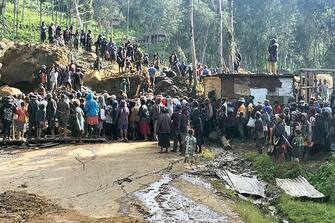 This handout photo taken on May 27, 2024 and received on May 28, 2024 from the International Organization for Migration shows locals gathering at the site of a landslide in Mulitaka village of the region of Maip Mulitaka, in Papua New Guinea's Enga Province. More than 2,000 people are feared buried in a Papua New Guinea landslide that destroyed a remote highland village, the government said on May 27, as it pleaded for international help in the rescue effort. (Photo by Mohamud Omer / International Organization for Migration / AFP) / RESTRICTED TO EDITORIAL USE - MANDATORY CREDIT "AFP PHOTO / INTERNATIONAL ORGANIZATION FOR MIGRATION / MOHAMUD OMER - NO MARKETING NO ADVERTISING CAMPAIGNS - DISTRIBUTED AS A SERVICE TO CLIENTS - NO ARCHIVE