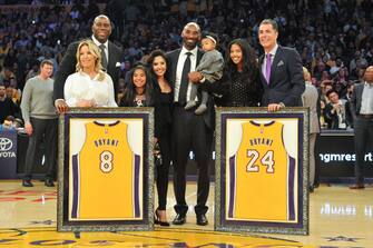 LOS ANGELES, CA - DECEMBER 18:  Magic Johnson, Jeanie Buss, Kobe Bryant, wife Vanessa Bryant and daughters Gianna Maria Onore Bryant, Natalia Diamante Bryant, Bianka Bella Bryant and Rob Pelinka pose for a picture during Kobe Bryant's jersey retirement ceremony at halftime of a basketball game between the Los Angeles Lakers and the Golden State Warriors at Staples Center on December 18, 2017 in Los Angeles, California.  (Photo by Allen Berezovsky/Getty Images)