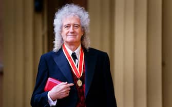 Brian May dopo la cerimonia di cavalierato mostra la medaglia