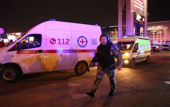 A law enforcement officer shouts outside the burning Crocus City Hall concert hall following the shooting incident in Krasnogorsk, outside Moscow, on March 22, 2024. Gunmen opened fire at a concert hall in a Moscow suburb on March 22, 2024 leaving dead and wounded before a major fire spread through the building, Moscow's mayor and Russian news agencies reported. (Photo by STRINGER / AFP)