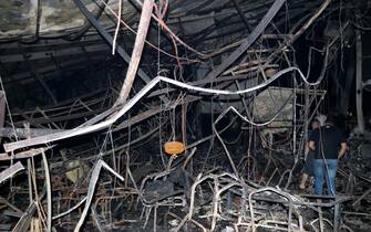 epa10885157 Iraqi men inspect the scene of a fire that broke out at a wedding hall in Hamdaniya, in Iraq's Nineveh province, north of Iraq, 27 September 2023. More than 100 people died and at least 150 are injured after a fire during a Christian wedding celebration in Iraq's Nineveh province.  EPA/MOHAMAD SAIF