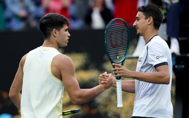 MELBOURNE, AUSTRALIA - JANUARY 18: Carlos Alcaraz (L) of Spain shakes hands with Lorenzo Sonego of Italy after winning his round two singles match during the 2024 Australian Open at Melbourne Park on January 18, 2024 in Melbourne, Australia. (Photo by Cameron Spencer/Getty Images)