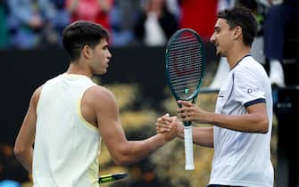 MELBOURNE, AUSTRALIA - JANUARY 18: Carlos Alcaraz (L) of Spain shakes hands with Lorenzo Sonego of Italy after winning his round two singles match during the 2024 Australian Open at Melbourne Park on January 18, 2024 in Melbourne, Australia. (Photo by Cameron Spencer/Getty Images)