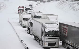 A large number of trucks are stuck on the E22 highway at Linderöd in southern Sweden on January 4, 2024, where up to 1,000 cars were stuck in queues since the day before due to large amounts of snow that had fallen on the roadway and restricted access, according to the police. (Photo by Johan Nilsson/TT / TT NEWS AGENCY / AFP) / Sweden OUT