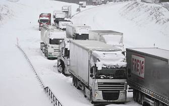 A large number of trucks are stuck on the E22 highway at Linderöd in southern Sweden on January 4, 2024, where up to 1,000 cars were stuck in queues since the day before due to large amounts of snow that had fallen on the roadway and restricted access, according to the police. (Photo by Johan Nilsson/TT / TT NEWS AGENCY / AFP) / Sweden OUT