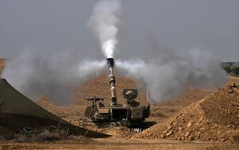 EDITORS NOTE: Graphic content / TOPSHOT - An Israeli army M109 155mm self-propelled howitzer fires rounds toward the Gaza Strip from a position in southern Israel across the border on October 28, 2023. Since the October 7 Hamas attack on Israel, the health ministry in the Palestinian enclave said more than 7,300 Palestinians have been killed by Israel's relentless retaliatory bombardments, mainly civilians and many of them children. (Photo by Aris MESSINIS / AFP)