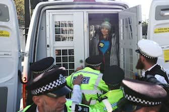 TOPSHOT - Swedish climate activist Greta Thunberg stands inside a police van after being arrested outside the InterContinental London Park Lane during the "Oily Money Out" demonstration organised by Fossil Free London and Greenpeace on the sidelines of the opening day of the Energy Intelligence Forum 2023 in London on October 17, 2023. (Photo by HENRY NICHOLLS / AFP) (Photo by HENRY NICHOLLS/AFP via Getty Images)