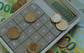 Counting money.Euro bills and coins. one hundred euro banknotes, euro coins gray calculator. Expenses and income.