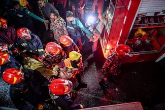EDITORS NOTE: Graphic content / Firefighters carry an injured person during rescue operations following a fire in a commercial building that killed at least 43 people, in Dhaka, on February 29, 2024. At least 43 people were killed and dozens injured after a fire blazed through a seven-storey building in an upscale neighbourhood in the Bangladeshi capital of Dhaka late on February 29, health authorities said. (Photo by Munir Uz Zaman / AFP) (Photo by MUNIR UZ ZAMAN/AFP via Getty Images)