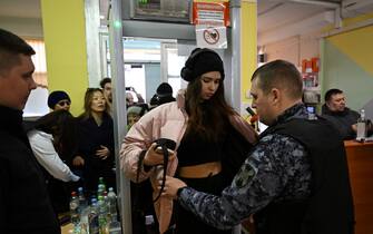 Una ragazza viene perquisita a un seggio in Russia