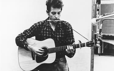 1962:  Bob Dylan recording in the studio with his acoustic guitar and an assortment of harmonicas in 1961 or 1962. (Photo by Michael Ochs Archives/Getty Images)