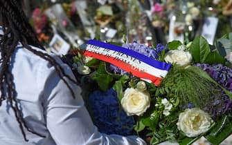 A member of the Centre Penitentiaire de Fresnes (The Fresnes Penitentiary Center) brings a wreath to lay in front of the entrance gate of the property of late French actor Alain Delon La Brulerie in Douchy, central France, on August 24, 2024. French film legend Alain Delon has died at the age of 88, his three children told AFP in a statement on August 18, 2024, following a battle with ill health. (Photo by GUILLAUME SOUVANT / AFP)