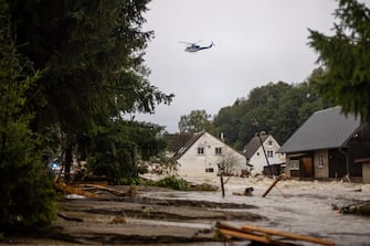 epaselect epa11606160 A police helicopter flies over overfloated houses in overfloating Bela river after heavy rain in town of Jesenik, Czech Republic, 15 September 2024. Floods caused by heavy rains have been battering central and eastern Europe since 13 September, with at least four dead in Romania, four missing in the Czech Republic, and alarming water levels recorded in Poland.  EPA/MARTIN DIVISEK