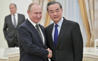 Russian President Vladimir Putin (L)shakes hands with Chinese State Councilor and Foreign Minister Wang Yi (R) as Russian Foreign Minister Sergei Lavrov (back) attends during their meeting in the Kremlin in Moscow, Russia, 05  April 2018. Wang Yi pays a working visit to Russia. ANSA/ALEXEI DRUZHININ / SPUTNIK / KREMLIN POOL