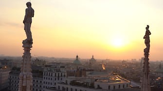 Europa, Italia, Milano - Vista sulla citta' dalle terrazze del Duomo al tramonto - La Madonnina e le guglie con vista sullo skyline grattacieli